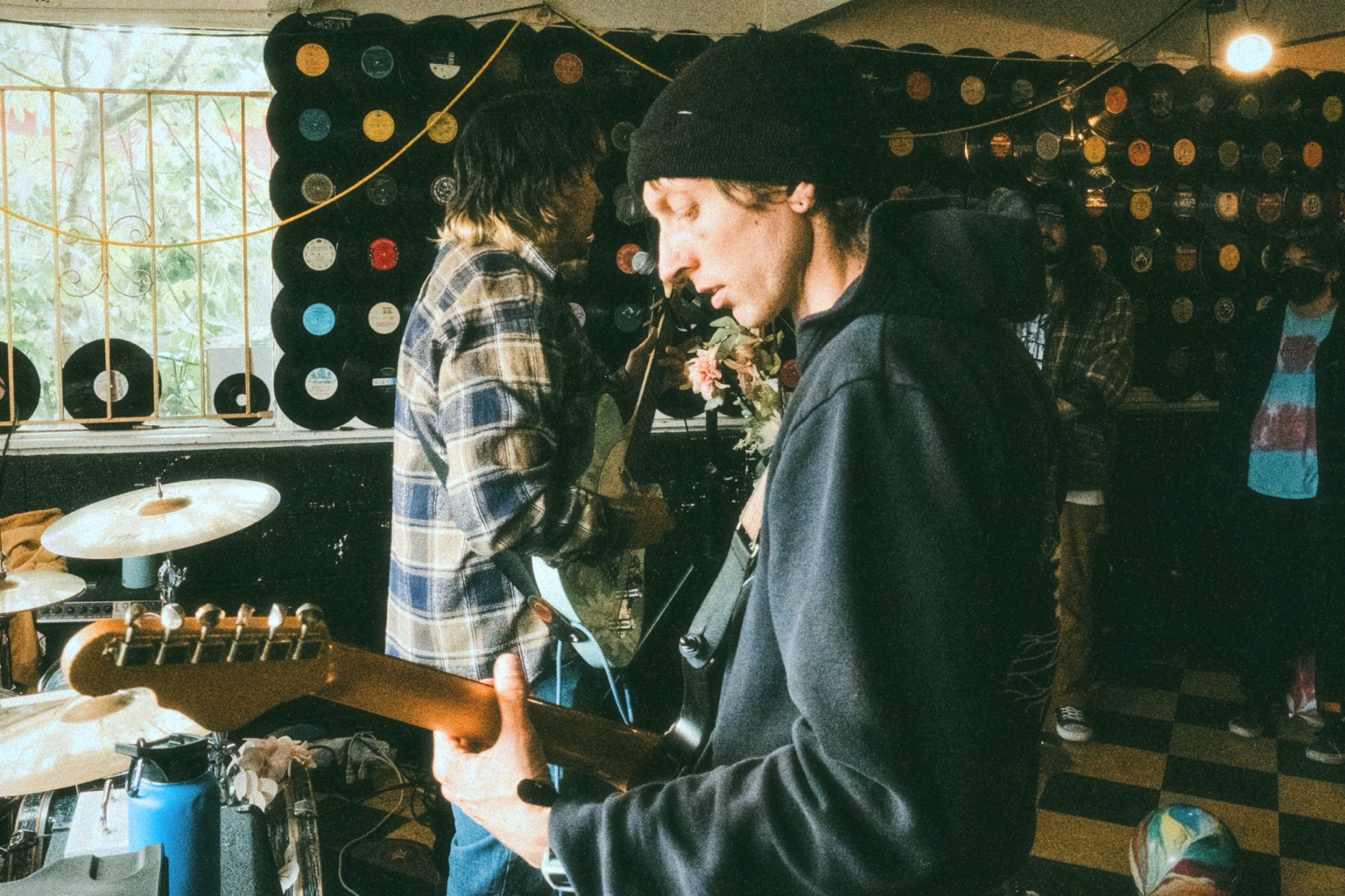 Geoff Nelson playing guitar in a record-lined room